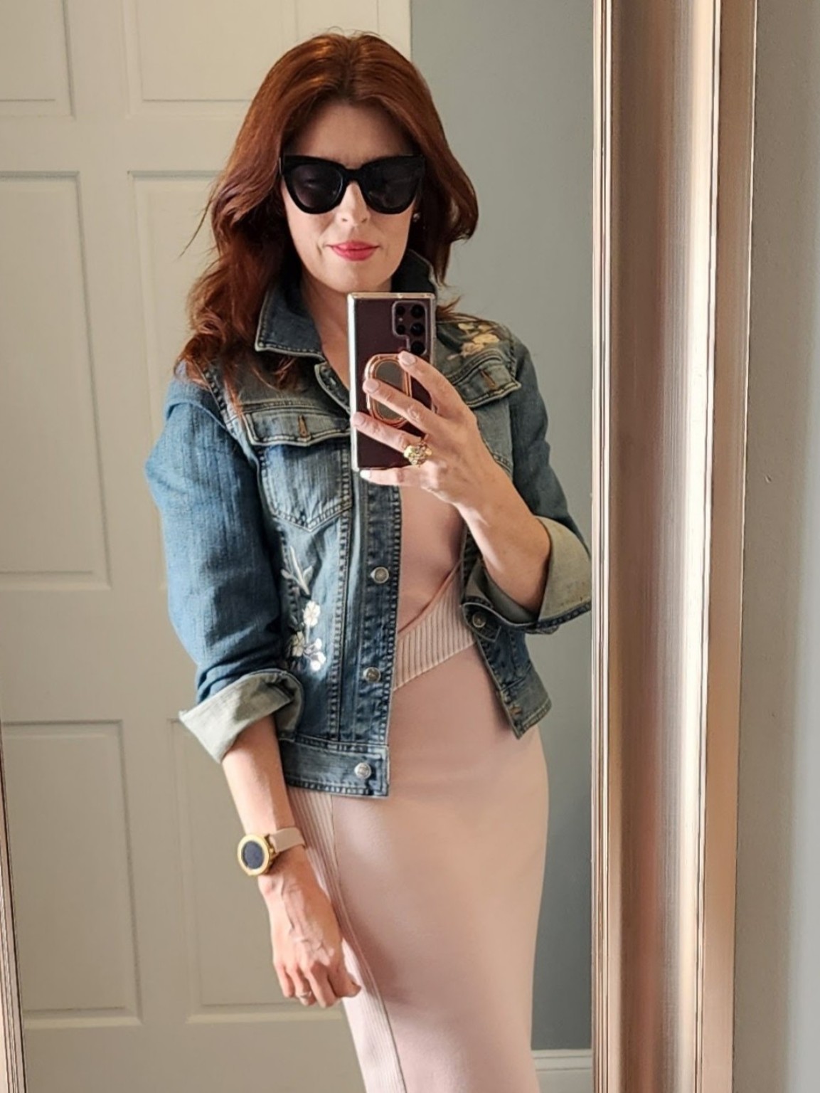 Cheyenne Dominguez photographing a styled outfit in a mirror